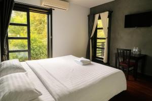 シェムリアップにあるPrana Hotelのベッドと机と窓のある寝室