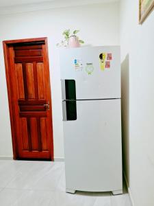 een witte koelkast naast een houten deur bij Casa Parque Verde Cop30 in Belém