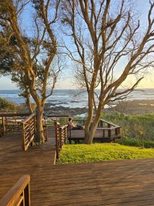 Sea ViewにあるShells on the Beachの海の近くの遊歩道のベンチに座っている人