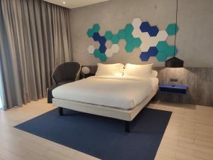 a hotel room with a bed and a chair at ibis Styles Batam Nagoya in Nagoya +66 photos