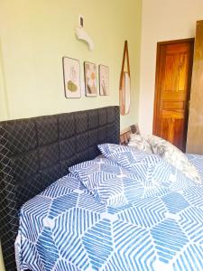 een bed met een blauw en wit dekbed in een slaapkamer bij Casa Parque Verde Cop30 in Belém