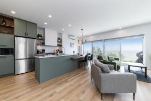 a kitchen and living room with a couch and a table at Havre du Loup: St. Lawrence River Views & Trails in Petite-Rivière-Saint-François