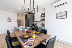 a kitchen and dining room with a wooden table and chairs at Havre du Loup: St. Lawrence River Views & Trails in Petite-Rivière-Saint-François +9 photos