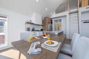 a kitchen and dining room with a table with food on it at Panorama 1253: Two-Level Sanctuary & Views in Petite-Rivière-Saint-François