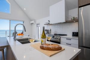 a kitchen with a bottle of wine and two glasses at Panorama 1253: Two-Level Sanctuary & Views in Petite-Rivière-Saint-François