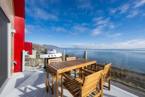 a patio with a table and a grill on a balcony at Panorama 1253: Two-Level Sanctuary & Views in Petite-Rivière-Saint-François