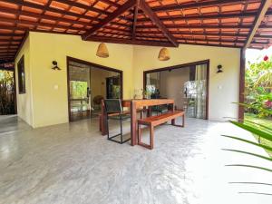 ein Esszimmer im Freien mit einem Holztisch und Stühlen in der Unterkunft Casa Gemini in Ilha de Boipeba + 24 Fotos