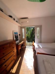 une chambre avec un lit, une commode et un bureau dans l'établissement Charmosa casa 4 suítes no Jd Europa, à São Paulo