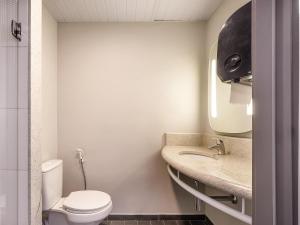 a bathroom with a toilet and a sink at ibis Osasco in Osasco