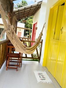 una hamaca en el porche de una casa en Villa Tropicana, en Saubara