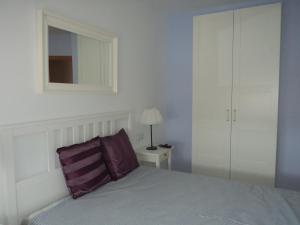 ヘレス・デ・ラ・フロンテーラにあるApartamento Centro Jerez Campillo Iのベッドルーム1室(紫色の枕と鏡付きのベッド1台付)