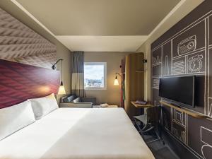 Una habitación de hotel con una cama y un televisor. en ibis Jacarei, en Jacareí