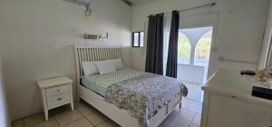 Un dormitorio pequeño con una cama y una ventana. en Wavecrest Suites, en Grand Anse