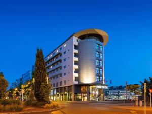 a large building with a domed roof at dusk at Novotel Tours Centre Gare in Tours