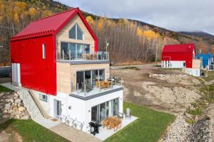 a house with a red roof on top of it at Panorama 1249: Garden-Level with Fireplace in Petite-Rivière-Saint-François +4 photos