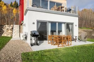 a house with a table and chairs and a grill at Panorama 1249, Majestic River View, Spacious Patio in Petite-Rivière-Saint-François
