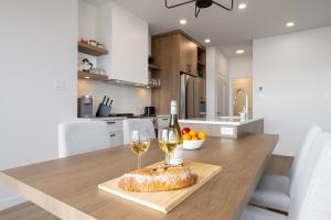 a table with two glasses of wine and a loaf of bread at Panorama 1251: Fireplace & Unforgettable Views in Petite-Rivière-Saint-François