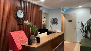 an office with a reception desk and a clock on the wall at Neela House in Labuan