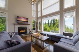 a living room with two blue couches and a fireplace at Phoenix 75: River view, Spa and Pool Table in Petite-Rivière-Saint-François