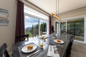 a dining room with a table and a large window at Phoenix 75: River view, Spa and Pool Table in Petite-Rivière-Saint-François