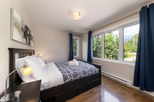 a bedroom with a bed and two windows at Phoenix 75: River view, Spa and Pool Table in Petite-Rivière-Saint-François
