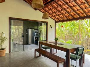 a dining room with a wooden table and chairs at Casa Gemini in Ilha de Boipeba