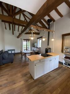 a kitchen and dining room with wooden floors and wooden ceilings at La P'tite Maiz in Bourg-de-Visa