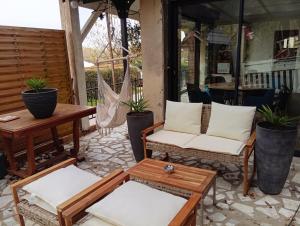 a patio with chairs and a table and a hammock at L'Escapade in Villers-sur-le-Roule
