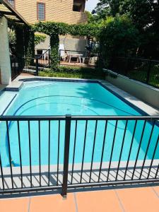 约翰内斯堡Melville Koppies View Guest house的一座游泳池四周环绕着金属围栏