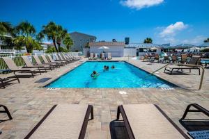 a swimming pool with chairs and people playing in it at The Vue 233 in Tybee Island