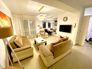 a living room with two couches and a tv at KENT Apartments in Prishtinë