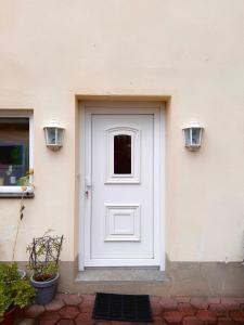 eine weiße Tür an einem Gebäude mit zwei Lichtern in der Unterkunft Apartment auf zwei Etagen - Casita in Burgstaedt + 2 Fotos