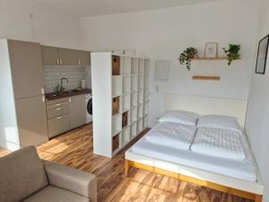 a small room with a bed and a kitchen at Studio 3 - Apartments am Schloss in Oberschleißheim