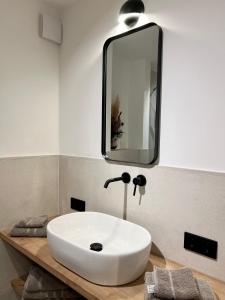 ヘルシング・アム・アンマーゼーにあるPittino Gartensuite 02 in zweiter Seereihe Ammerseeの白い洗面台と鏡のあるバスルーム