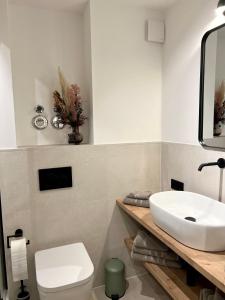 ヘルシング・アム・アンマーゼーにあるPittino Gartensuite 02 in zweiter Seereihe Ammerseeの白い洗面台とトイレのあるバスルーム +7枚の写真