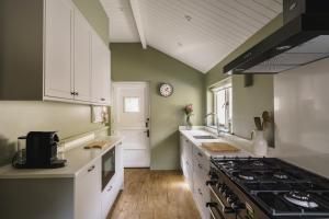 a kitchen with green walls and a stove top oven at 2 Hart Head Barn, Renovated Barn, Ambleside in Rydal