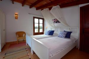 - un lit blanc avec des oreillers bleus dans l'établissement Encantadora finca con piscina en la naturaleza, à Caimari 27 autres photos