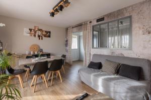 ein Wohnzimmer mit Sofa und Tisch in der Unterkunft Gite Du Ptit Lou in Noyers-sur-Cher