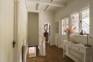 a hallway with white walls and a table with flowers on it at 2 Hart Head Barn, Renovated Barn, Ambleside in Rydal +68 photos