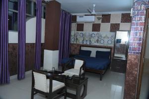 1 dormitorio con cama azul, escritorio y silla en siti castle jalandhar, en Jalandhar