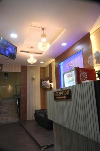 Un vestíbulo de hotel con un mostrador de recepción y un cartel. en siti castle jalandhar, en Jalandhar