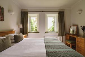a bedroom with a bed and two windows at 2 Hart Head Barn, Renovated Barn, Ambleside in Rydal