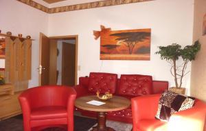 a living room with a couch and a table and chairs at Blick In Die Natur in Ilmenau