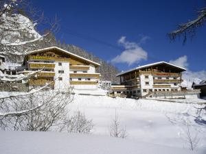 a couple of buildings on a snow covered mountain at Sonnenhotel Soldanella Sonneck in Samnaun