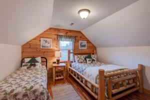 a bedroom with two beds in a log cabin at River Roost in Todd