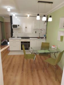 una cucina con tavolo in vetro e sedie verdi di Солнечная Набережная 6 a Dnipro