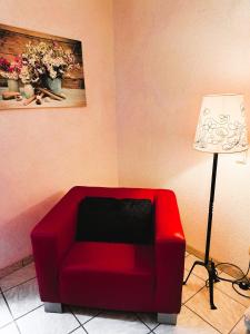 un canapé rouge placé dans une pièce à côté d'une lampe dans l'établissement Ferienwohnung Mit Garten Und Parkplatz, à Neumagen-Dhron 10 autres photos