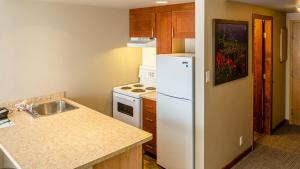 a kitchen with a white refrigerator and a sink at Cahilty #346 home in Sun Peaks