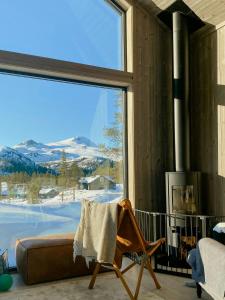 ein Wohnzimmer mit Couch und großem Fenster in der Unterkunft Modern Family Cabin By The Ski Trail In Tuddal in Tuddal