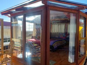 a glass house with a room with a bed at Uros Titicaca UMA lodge in Puno +6 photos